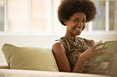 Woman using digital tablet on sofa