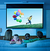 Family watching television in living room