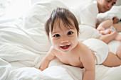 Baby girl crawling in bedsheets
