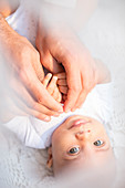 Father holding baby boy's hands