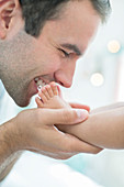 Father kissing baby boy's feet