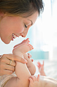 Mother kissing baby girl's feet