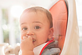 Baby boy eating in high chair