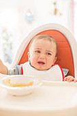 Baby boy crying in high chair