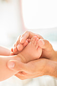 Father cradling baby boy's feet