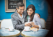 Couple using cell phone, Paris