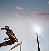 Track and field athlete clearing hurdle
