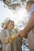 Senior couple holding hands under trees