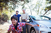 Multi-generation men outside car
