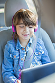 Happy girl using tablet in car