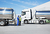 Workers talking next to tankers