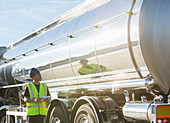 Worker with clipboard checking tanker