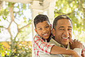 Smiling grandfather and grandson hugging