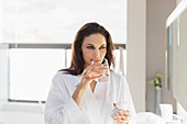 Woman taking medication in bathroom