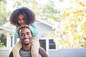 Father carrying daughter on shoulders