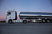 Steel milk tanker on the road at night