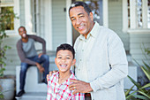 Grandfather and grandson outside house