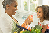 Grandmother giving apple to granddaughter