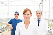 Scientists and worker in greenhouse