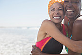 Enthusiastic women hugging on beach