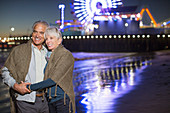 Senior couple hugging on beach at night