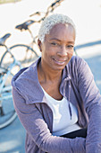 Portrait of smiling woman near bicycle