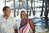 Senior couple on beach near pier