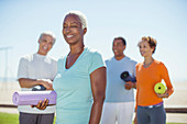 Senior woman with yoga mat in park