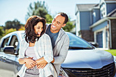 Happy couple hugging in driveway