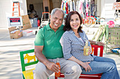 Smiling couple drinking soda at yard sale