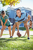 Family playing football in grass