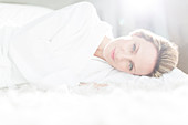 Woman in bathrobe laying on bed