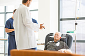 Two doctors talking to senior patient