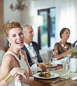 Woman laughing at dinner party