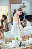 Woman setting table at dinner party