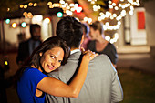 Couple hugging at party