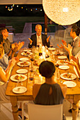 Friends applauding man at dinner party