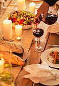 Woman pouring wine at dinner party