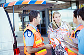 Paramedics talking to patient parking lot