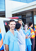 Nurse smiling by ambulance parking lot