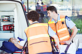 Paramedics examining patient on stretcher