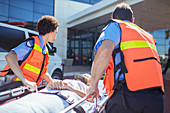 Paramedics wheeling patient parking lot