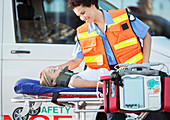 Paramedic examining patient on stretcher