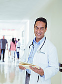 Doctor reading medical chart hallway