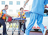 Paramedics wheeling patient parking lot