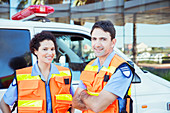 Paramedics smiling outside ambulance