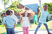 Children jumping on trampoline outdoors