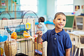 Student examining birdcage in classroom