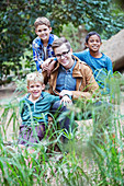 Students and teacher smiling in forest