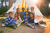 Students and teacher smiling at campsite